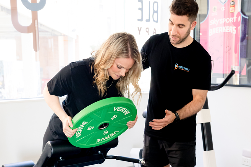 Physiotherapist assists athlete with specific exercises